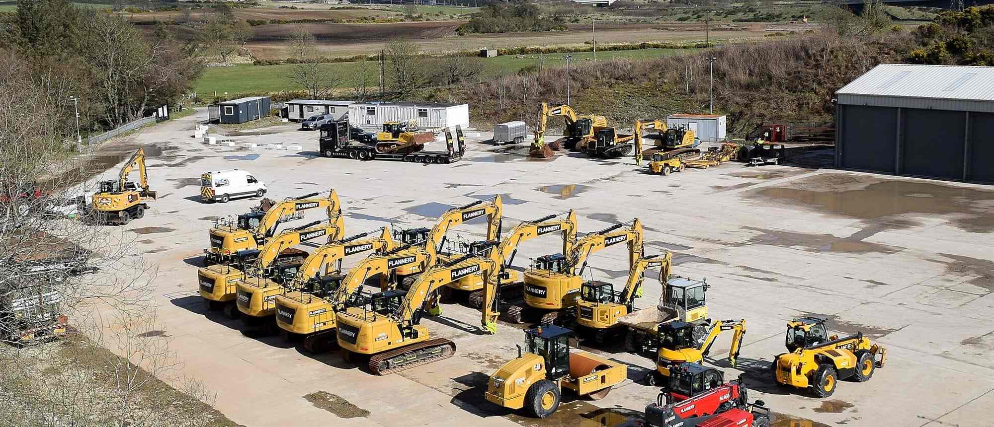 Rows of mini excavators, dumpers and telehandlers parked across a plant hire depot yard